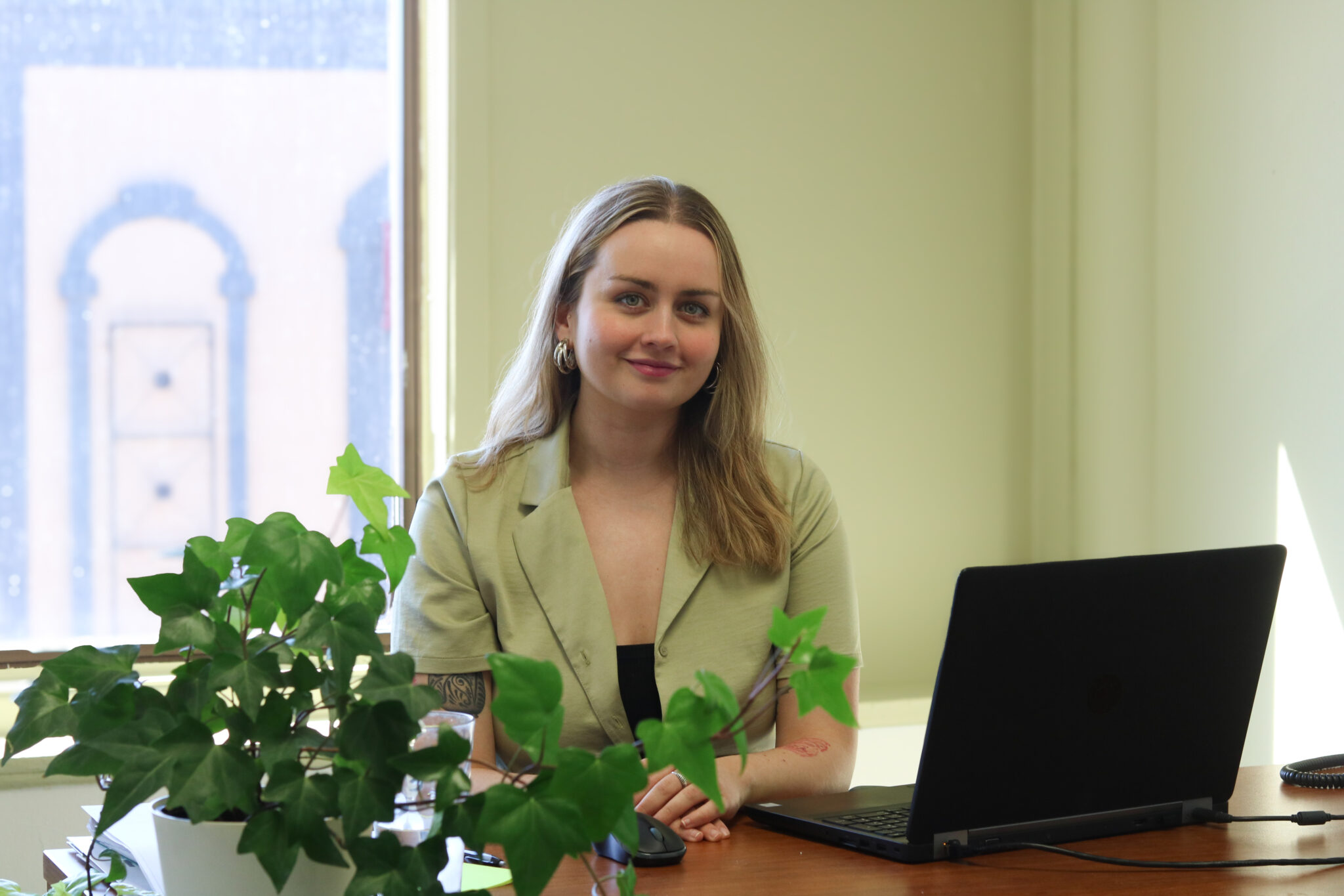 Une employée de la jonction, assise à son bureau, sourit.