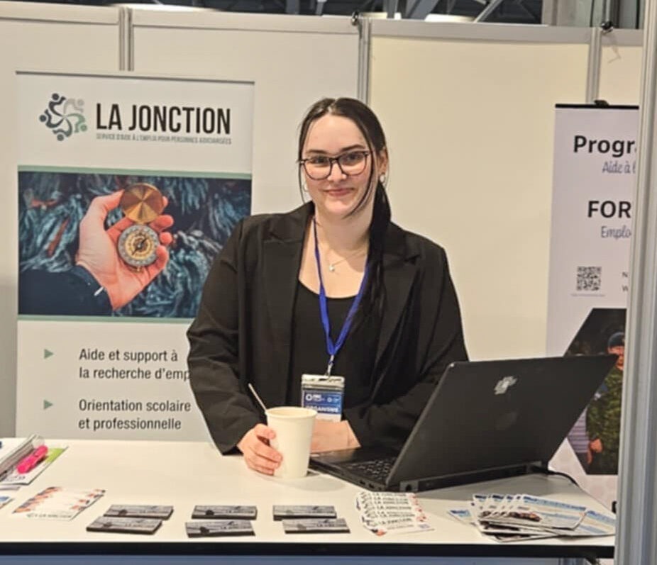Employée de La Jonction souriante à un kiosque.